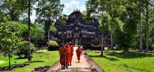 Traveler biking through Angkor jungle trails on a private cycling adventure past ancient temples and lush forests in Cambodia.