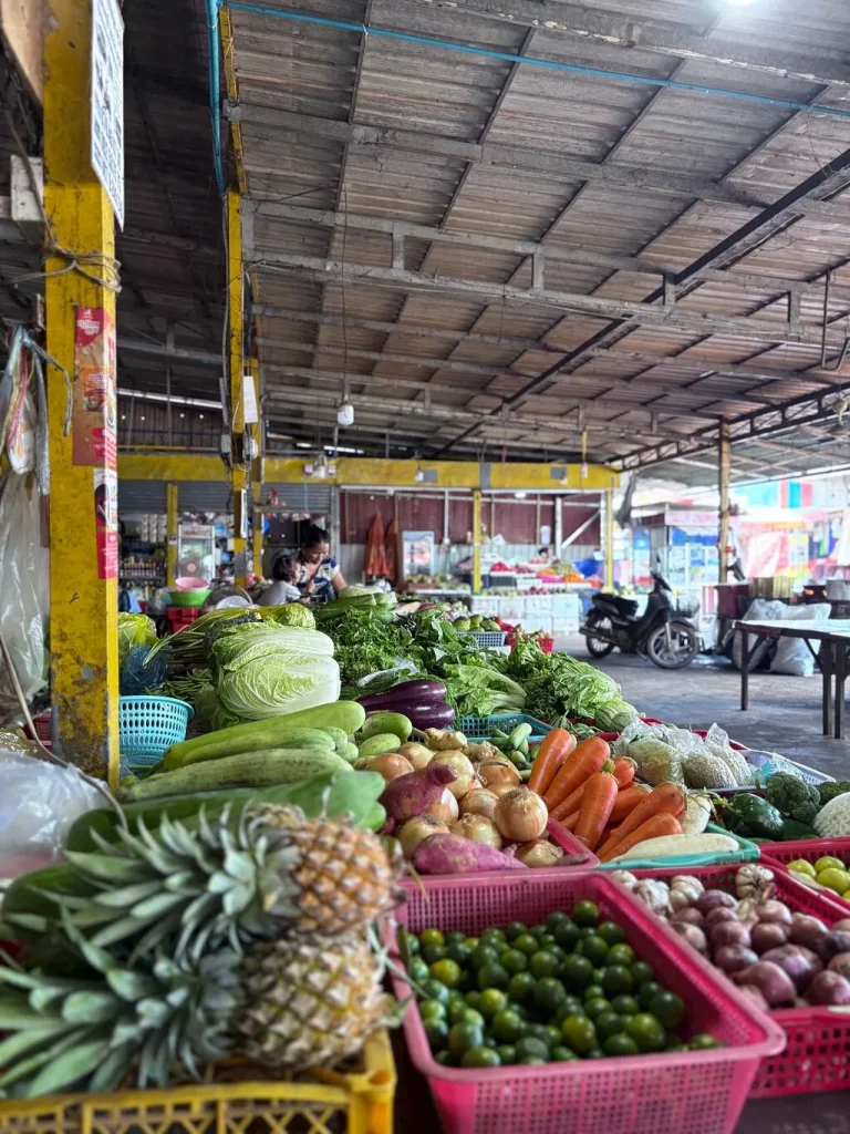 Fresh vegetables, limes and pineapples piled high at the local market visited before the cooking class